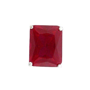 May include: A single, rectangular, deep red gemstone with a faceted surface. The gemstone is set with four small, silver-colored prongs at each corner, against a white background. The gem is a vibrant, saturated color.