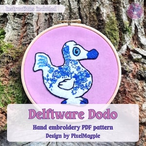May include: An embroidery hoop with a Delftware Dodo design. The dodo bird is white with blue floral patterns and a blue beak, stitched on pink fabric. The text "Instructions included" is visible. The text "Delftware Dodo" is also visible.