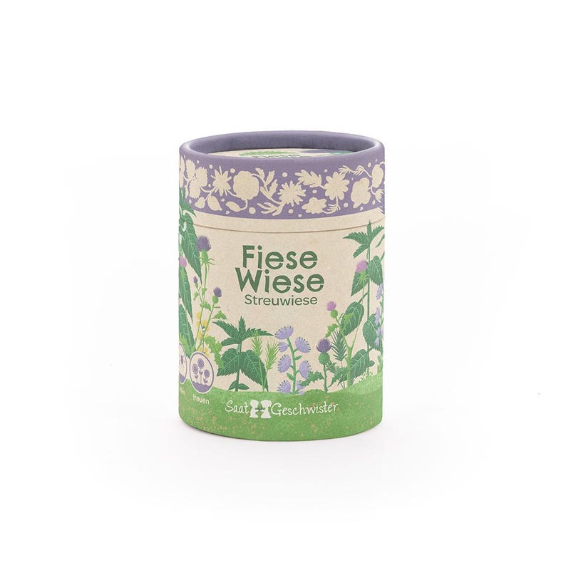 Puede incluir: Un recipiente cil&iacute;ndrico con un dise&ntilde;o floral y bot&aacute;nico. El recipiente tiene un borde y una base de color p&uacute;rpura claro, con las palabras "Fiese Wiese" y "Streuwiese" impresas en la parte delantera. El recipiente est&aacute; lleno de semillas.
