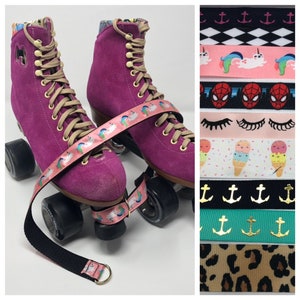 May include: Pink roller skates with black wheels and a black strap with a rainbow unicorn print. The strap is attached to the skates with a gold D-ring. The image also shows a variety of colorful ribbon designs.