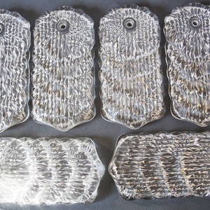 May include: Six clear glass ceiling light fixture covers with a textured, rippled surface. The covers have a hole in the center for the light bulb.