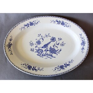 Op de afbeelding: Een witte ovale serveerschaal met een blauw bloemenmotief en een vogel in het midden.