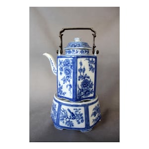 May include: A blue and white porcelain teapot with a matching warmer. The teapot has a square shape with floral designs and a metal handle. The warmer has a hexagonal base with bird and floral patterns.