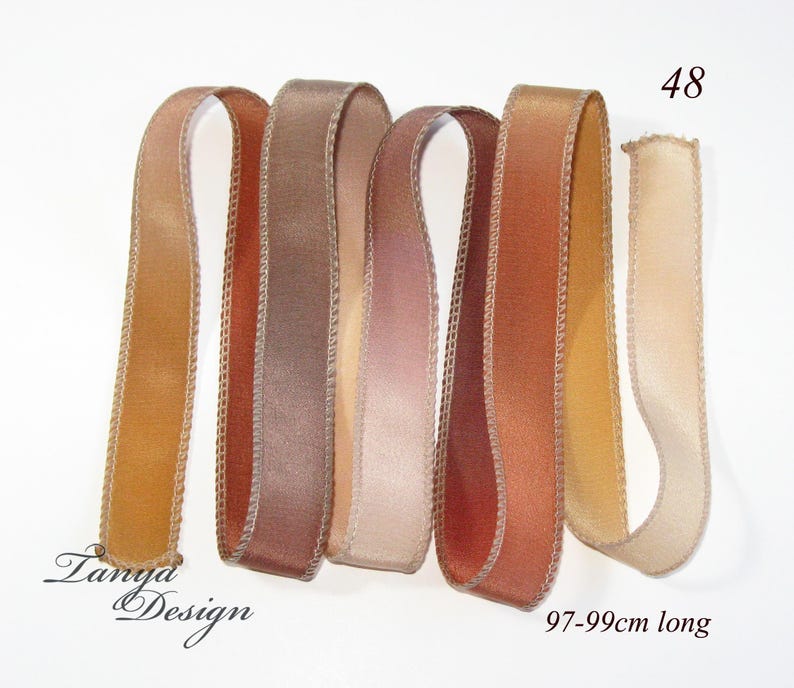 May include: Five different colored satin ribbon spools, each with a different shade of brown, beige, and orange. The ribbons are 97-99cm long.