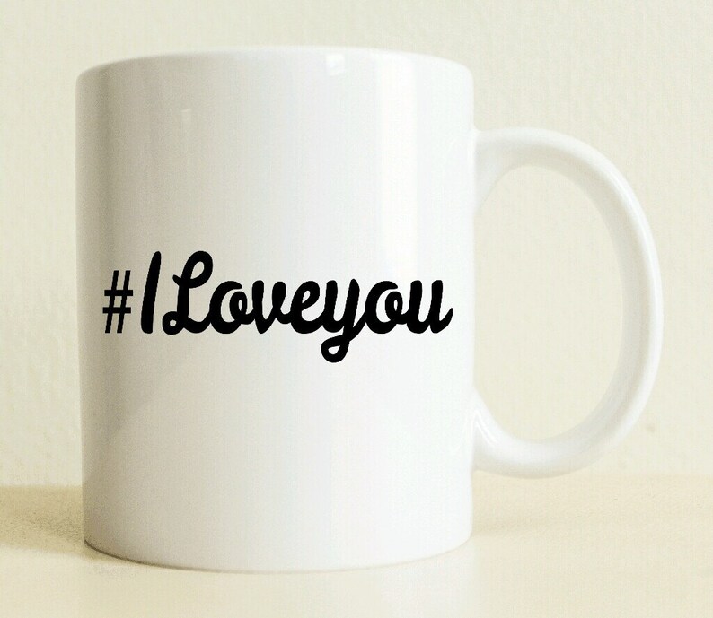 May include: White ceramic coffee mug with a black hashtag and the text "#Loveyou" in a cursive font.