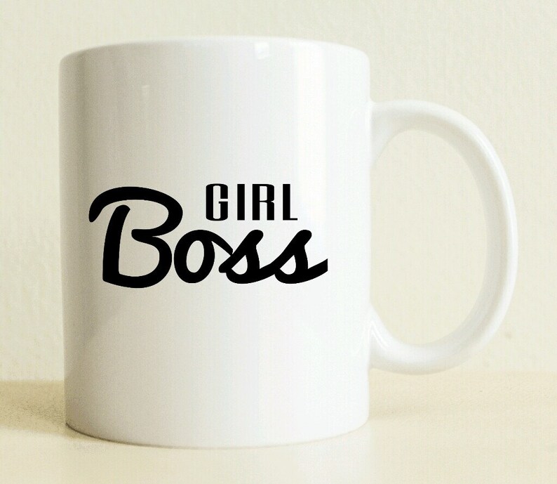 May include: White ceramic mug with a black cursive inscription that reads "Girl Boss".