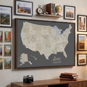 May include: A framed map of the United States with pins, surrounded by framed landscape photos and National Park posters. A shelf holds a globe, books, and a compass. The text on the map reads "The Adventures of the Imgarten Family."