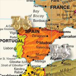 Peut inclure: Une carte de l'Europe avec un train jouet en or sur l'Espagne et un train jouet en argent sur l'Algérie. La carte montre les pays du Portugal, de l'Espagne, de la France, d'Andorre et de l'Algérie.