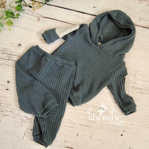 May include: A set of three ceramic nesting bowls in shades of blue, green, and white. The bowls feature a speckled glaze and a simple, modern design. The largest bowl is approximately 7 inches in diameter.