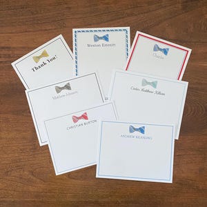 May include: Set of 7 personalized stationery cards with bow tie designs. The cards feature different colored bow ties with names printed below each bow tie. The names are: Thank You!, Mathew Johnson, Weston Emmitt, Charlie, Carter Matthew Killian, Christian Burton, and Andrew Keasling.