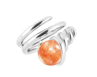 May include: Silver ring with a spiral design and a round orange sunstone.