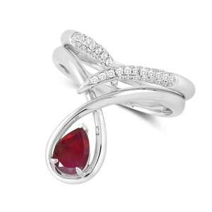 May include: A silver ring with a pear-shaped ruby gemstone and a diamond-encrusted band.