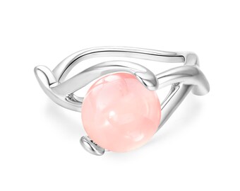 Puede incluir: Un anillo de plata con un delicado diseño de banda retorcida. Una gran piedra preciosa redonda de color rosa pálido está engastada en el centro del anillo.
