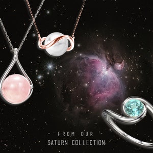 May include: Three silver necklaces with different pendants. The first necklace has a pink stone in a teardrop-shaped setting. The second necklace has a white pearl in a silver and rose gold setting. The third necklace has a light blue stone in a silver setting. The necklaces are displayed against a black background with a nebula.