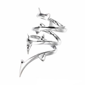 May include: Silver ring with a spiral design and black gemstones. The ring is made of multiple bands that twist and turn around each other.