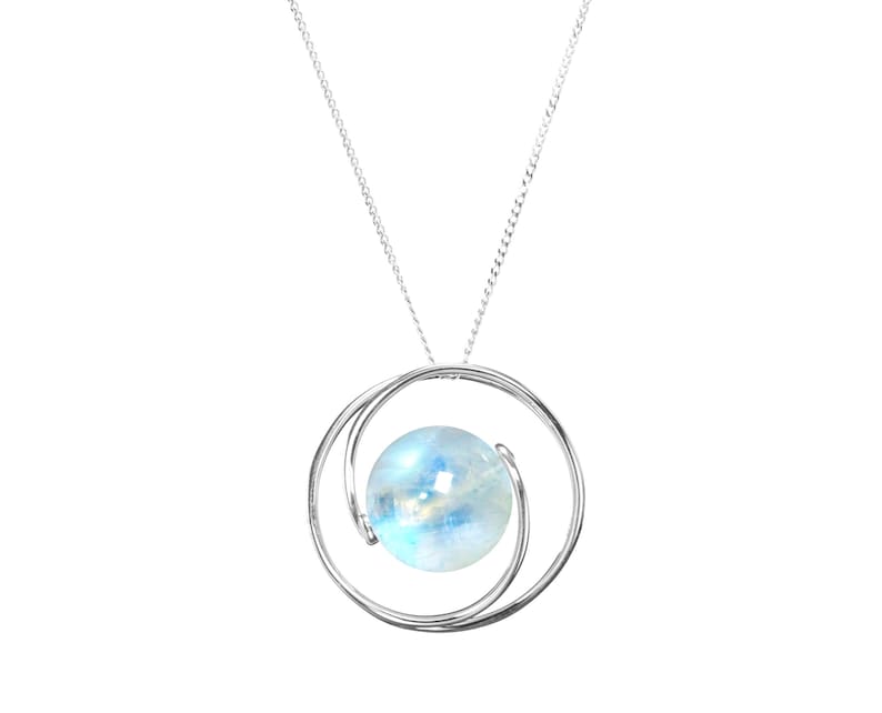 May include: A silver chain necklace with a pendant featuring a round, iridescent moonstone set in a silver double circle design.