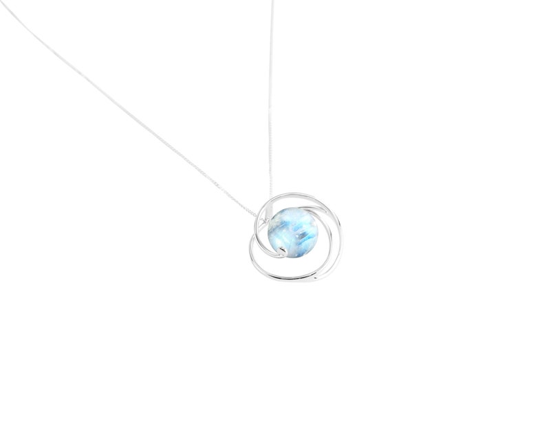May include: A silver necklace with a blue and white gemstone pendant surrounded by a silver circle.
