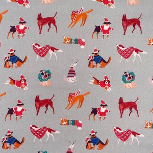 May include: A repeating pattern of dogs wearing Santa hats, scarves, and reindeer antlers on a light grey background. The dogs are in various poses, including sitting, standing, and running. Some dogs are wearing plaid scarves, while others are wearing red and white striped scarves. The dogs are all wearing Santa hats with white fur trim.