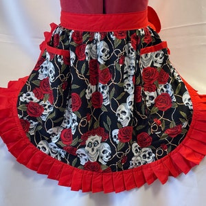 Meio avental/pinny retrô vintage estilo anos 50 com 2 bolsos - caveiras e rosas em preto com acabamento vermelho