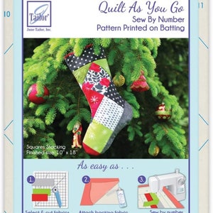 Peut inclure: Patron de couture Quilt As You Go Sew By Number imprimé sur ouate. Le motif est pour une chaussette mesurant 25,4 cm par 45,7 cm. L'image montre une chaussette colorée accrochée à un sapin de Noël vert.