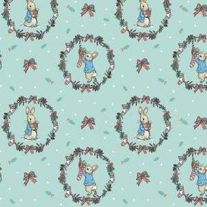 May include: A seamless pattern featuring a cute bunny rabbit holding a Christmas stocking in front of a wreath with red bows and holly. The background is a light blue color with white polka dots.