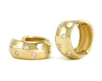 May include: A pair of gold hoop earrings with small diamonds set around the edge.