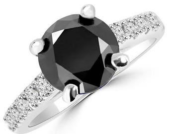 May include: A silver engagement ring with a large black diamond center stone and a band of smaller white diamonds.