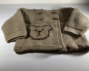 A lovely hand knit sweater with a bear applique