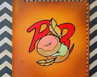 May include: A brown leather wallet with a red and white donut design and the letters "PB" in red. The wallet has white stitching around the edges.
