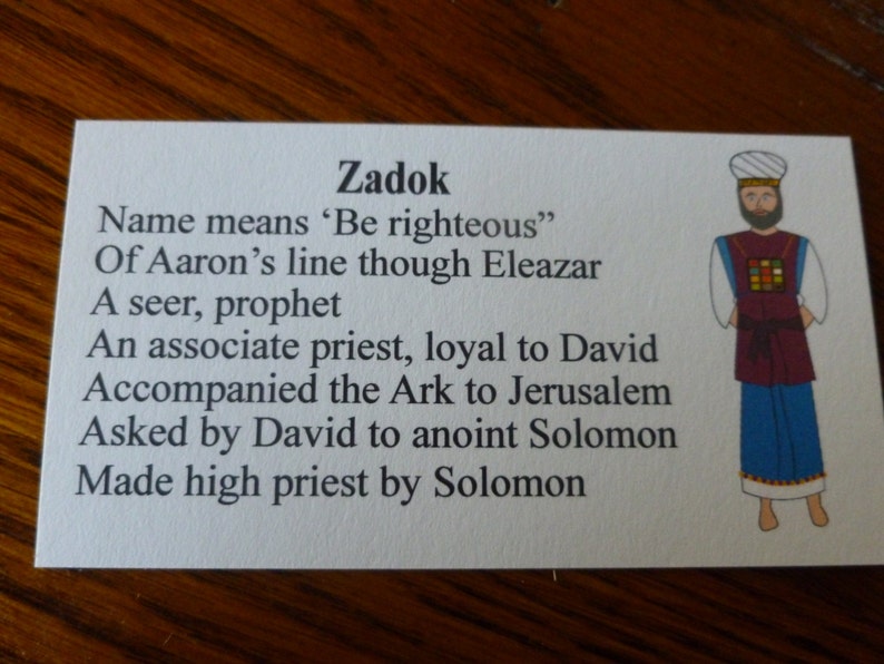 May include: A white card with black text about Zadok, a biblical figure. The text explains that Zadok was a seer, prophet, and associate priest who was loyal to David. The card also includes an illustration of Zadok wearing a colorful robe.
