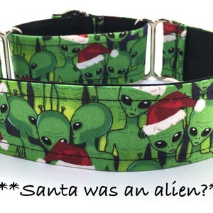 May include: Green dog collar featuring a pattern of green aliens wearing Santa hats. The collar has a black interior and silver hardware. Text at the bottom reads, "Santa was an alien?"