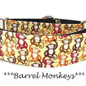 May include: A yellow, brown, orange, and red dog collar with a pattern of monkeys. The collar has silver hardware and is made of fabric. The text "***Barrel Monkeys***" is printed below the collar.