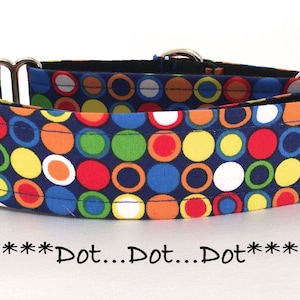 May include: A blue dog collar with a colorful polka dot pattern. The collar has silver hardware and is made of fabric.