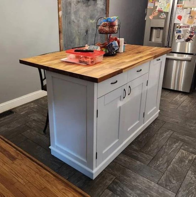 kitchen island white with 2 drawers and 2 storage cabinets with trash compartment. Custom kitchen island with overhang for seating.