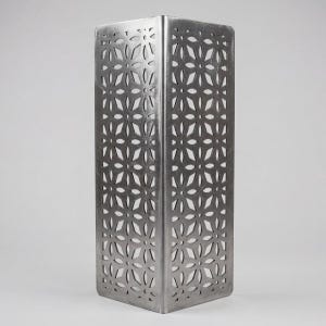 Puede incluir: Una linterna decorativa de metal plateado con forma rectangular. Los lados presentan un patrón floral recortado en el metal. La linterna está diseñada para contener una vela o fuente de luz, creando un efecto de iluminación decorativo.