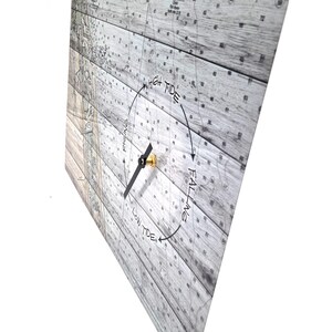 May include: A square tide clock featuring a nautical map background printed on a light gray wood grain pattern. The clock face displays the text High Tide, Low Tide, Rising, and Falling with a single black hand and a gold center mechanism.