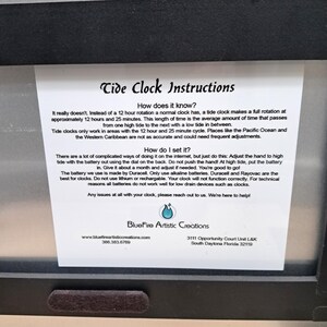 May include: A white instructional card for a tide clock with black text titled Tide Clock Instructions. It explains how the clock functions on a 12 hour and 25 minute cycle, how to set the hand, and battery recommendations by BlueFire Artistic Creations.