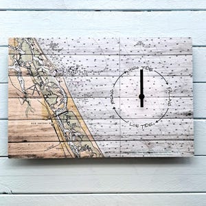 May include: A rectangular wooden wall clock featuring a nautical chart design. The clock face indicates tide levels with the words "High Tide," "Low Tide," "Rising," and "Falling." The clock hands are black.