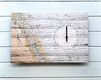 May include: A rectangular wooden wall clock featuring a nautical chart design. The clock face indicates tide levels with the words "High Tide," "Low Tide," "Rising," and "Falling." The clock hands are black.