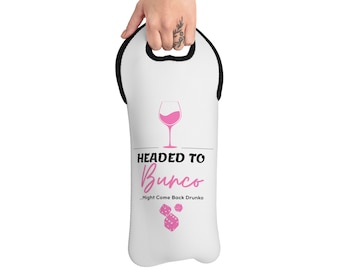 Op de afbeelding: Witte wijnfles draagtas met een roze wijnglas en een dobbelsteenmotief. De tekst luidt "Headed to Bunco...Might Come Back Drunko".