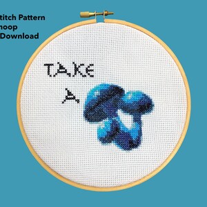 May include: Cross stitch pattern in a 6-inch hoop featuring a blue mushroom with the text "TAKE A" above it.