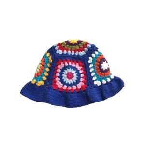 May include: A handmade crochet bucket hat. The hat features a vibrant, multicolored floral design on the crown, with a deep blue brim. The crochet work showcases a variety of colors, including red, pink, yellow, and blue.