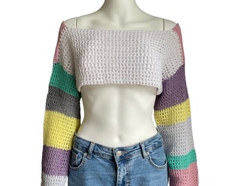 Op de afbeelding: Een wit gehaakt topje met regenboogkleurige strepen op de mouwen. Het topje is kort en heeft een brede, off-shoulder halslijn.