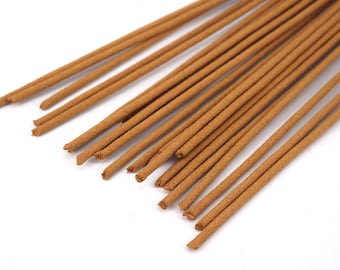 Può includere: Una collezione di bastoncini di incenso marroni disposti diagonalmente su uno sfondo bianco. I bastoncini di incenso sono cilindrici e hanno un aspetto ruvido e strutturato. Le punte dei bastoncini sono leggermente sfilacciate.