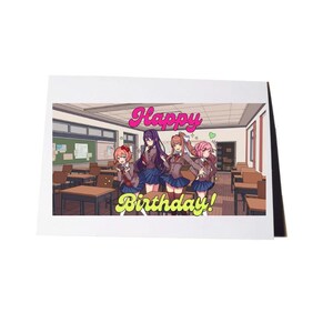 Pode incluir: Um cartão de felicitações retangular com uma ilustração em estilo anime de quatro personagens numa sala de aula. O texto "Happy Birthday!" está impresso em letras grandes, coloridas e estilizadas no centro da imagem sobre os personagens.