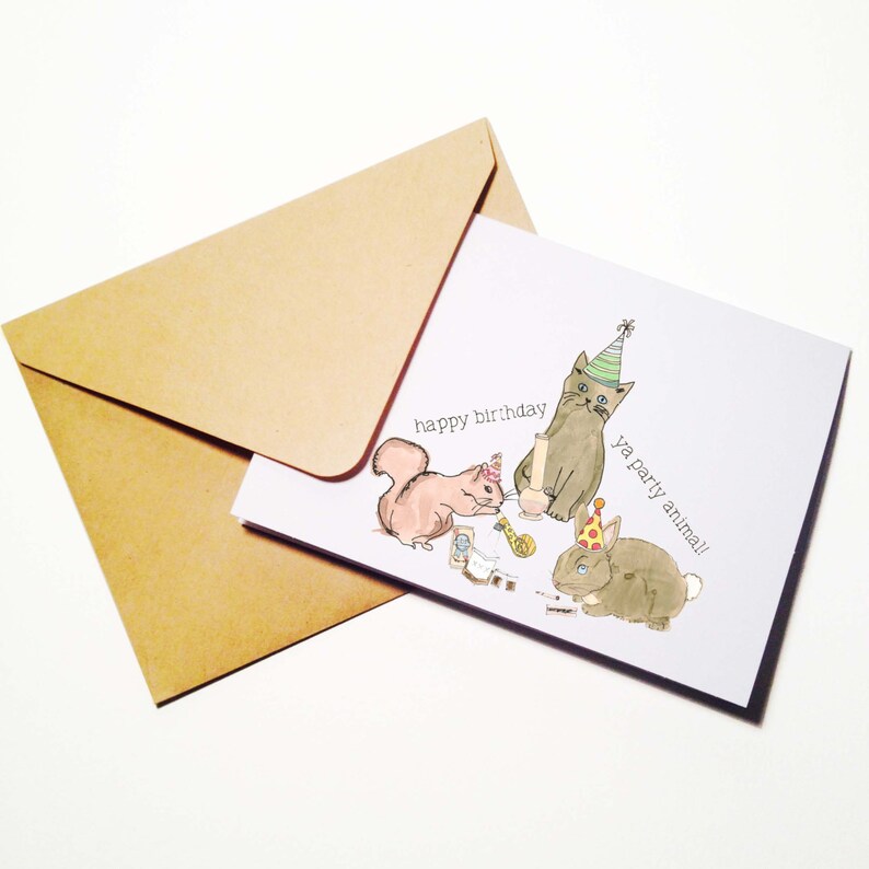 May include: A birthday card with a gray cat, a brown rabbit, and a squirrel wearing party hats. The card says "happy birthday ya party animal!"