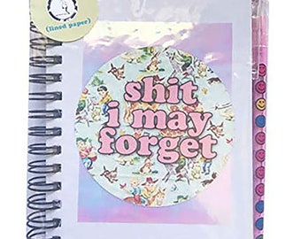 Puede incluir: Una libreta blanca con una pegatina rosa y azul que dice "shit i may forget". La libreta tiene una encuadernación en espiral y viene con un bolígrafo rosa con un patrón de caritas sonrientes.