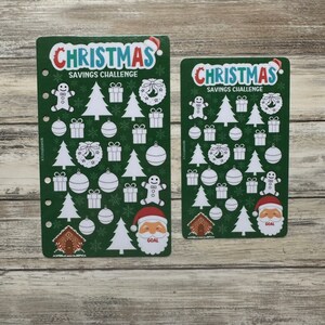 May include: Two green Christmas savings challenge cards with white outlines of Christmas trees, ornaments, presents, wreaths, gingerbread houses, and Santa Claus. The text "CHRISTMAS SAVINGS CHALLENGE" is at the top of each card.