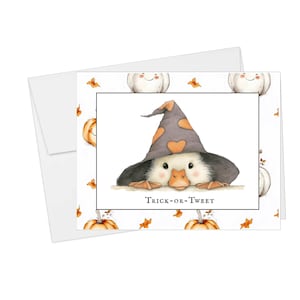 Pu&ograve; includere: Biglietto di auguri a tema Halloween con un'anatra che indossa un cappello da strega con dettagli a cuore arancione. La carta recita "Trick-or-Tweet" ed &egrave; decorata con zucche e foglie autunnali. Include una busta bianca.