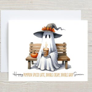 May include: A watercolor illustration of a friendly ghost wearing a witch hat and holding a pumpkin spice latte. The ghost is sitting on a wooden bench with a small pumpkin nearby. Text reads: Happy Pumpkin Spiced Latte, Double Cream, Double Whip Season.